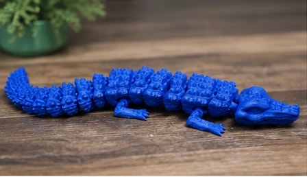 Blue textured caterpillar toy on wooden surface